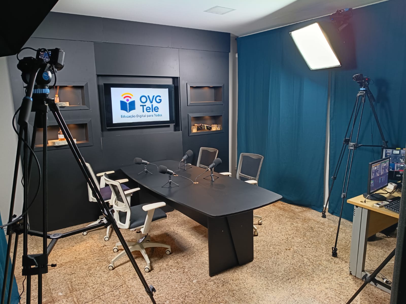 Estúdio 02 da OVG com mesa de gravação e microfones profissionais